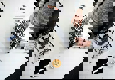 En person som sitter vid sin dator i ett konferensrum